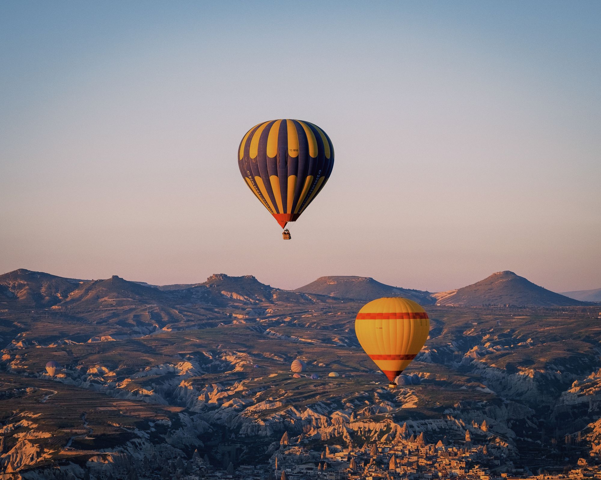 Hot-air balloons floating above the dramatic landscape of Cappadocia